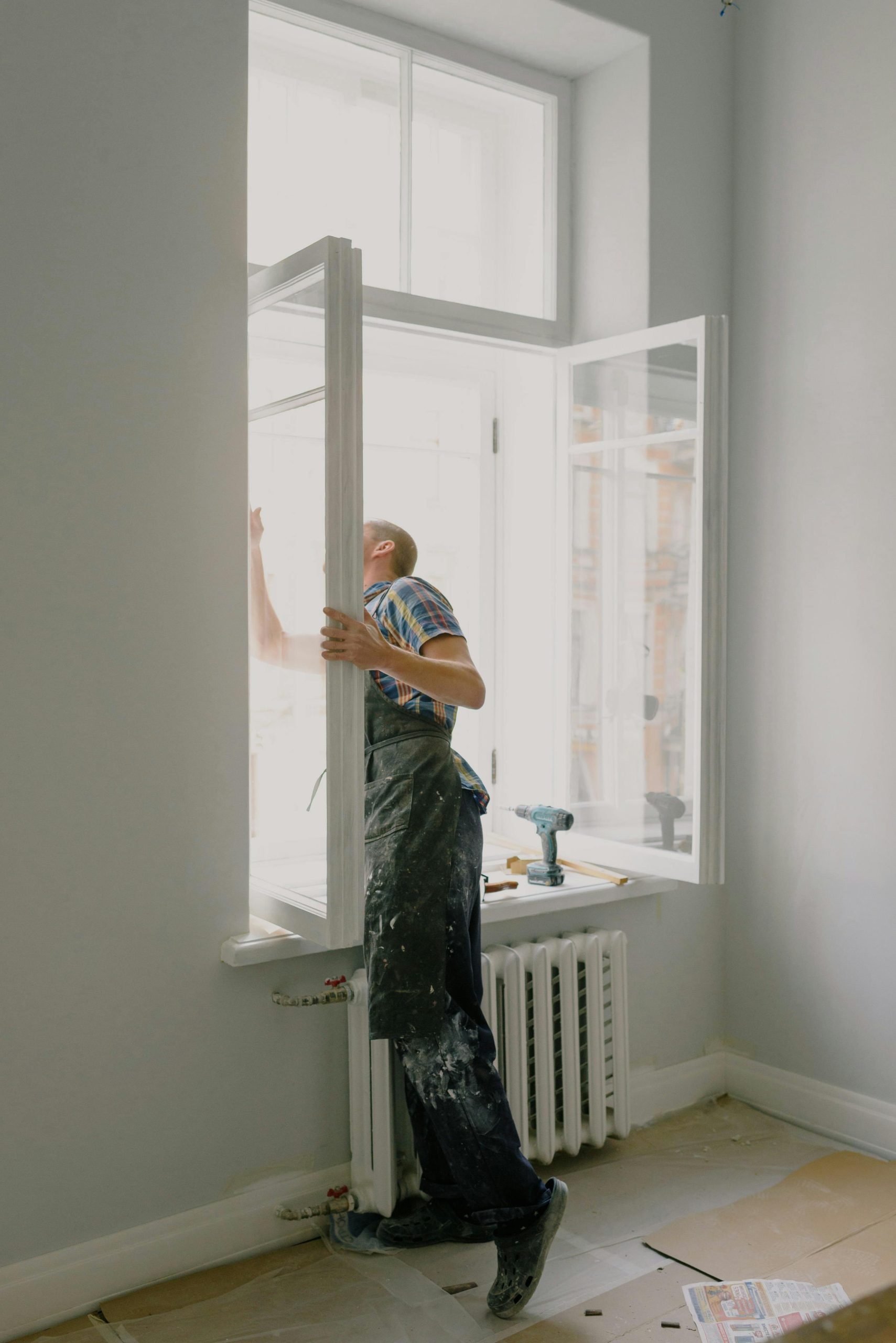 Professional installing a window in a bright modern apartment interior.